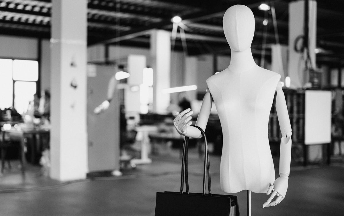 A mannequin holding a black tote in the Poelle atelier